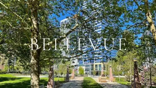 Branded "BELLEVUE" city guide image showing Bellevue Downtown Park's leafy tree canopy framing the rising glass-and-steel towers of the Bellevue Washington skyline — courtesy of Matthew Konsmo, Coldwell Banker Danforth.