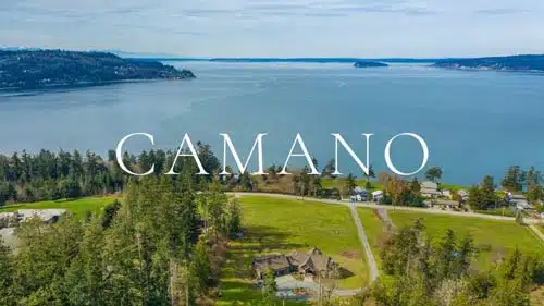 Branded "CAMANO" aerial image of an Arrowhead Road water-view estate set on rolling pasture above Utsalady Bay on Camano Island, WA, with Whidbey Island and Saratoga Passage in the distance.