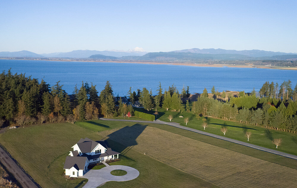 White modern farm house on Northside of Camano Island WA with view of Skagit Bay.