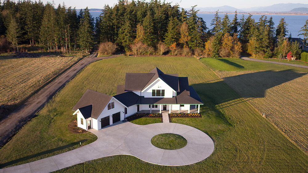 Drone photo of White modern farm house on Northside of Camano Island WA