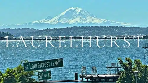 View from the Laurelhurst neighborhood in Seattle showing Lake Washington, a private dock, the NE Laurelcrest Lane street sign, and snow-capped Mount Rainier in the distance.