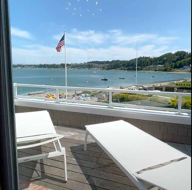 Waterfront deck with lounge chairs overlooking Utsalady Bay on Camano Island, WA, from a sold home represented by Matthew Konsmo, Coldwell Banker Danforth