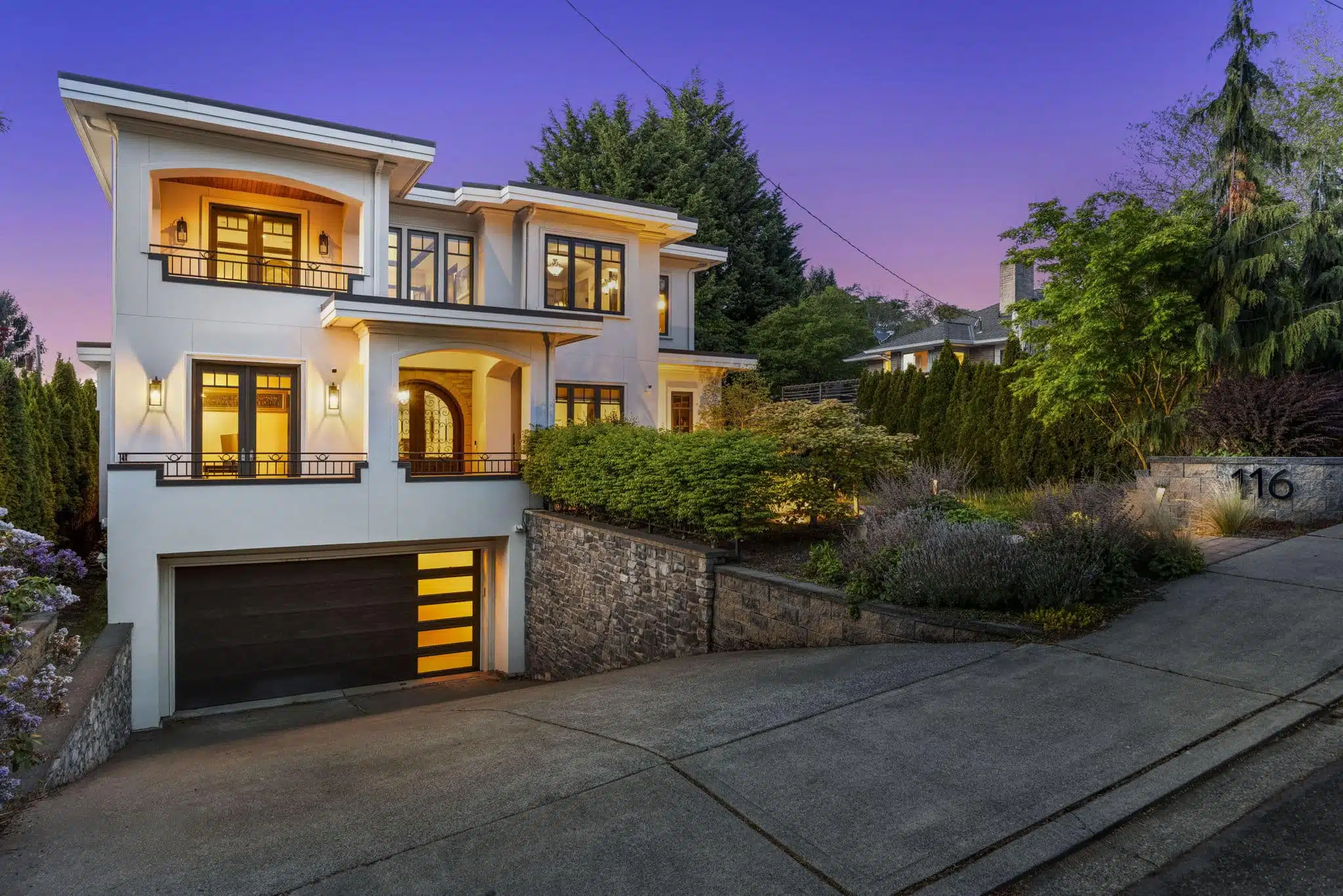Mediterranean-style luxury home glowing at twilight in Kirkland's East of Market neighborhood
