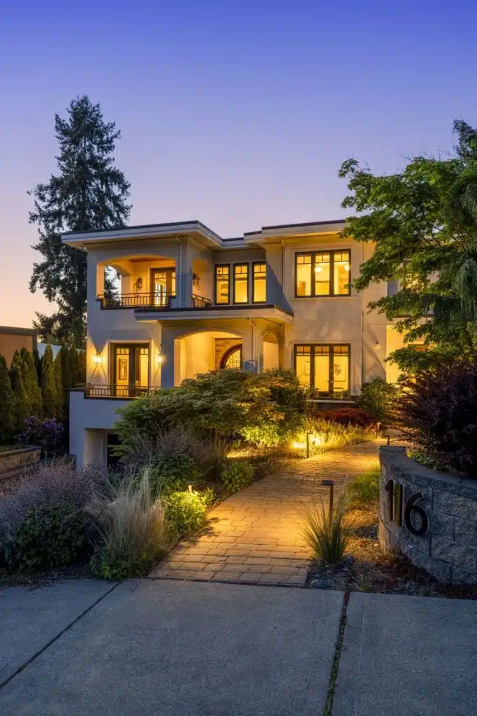 Warm evening view of the home's grand entry and architectural detailing, illuminated against the Pacific Northwest sky.