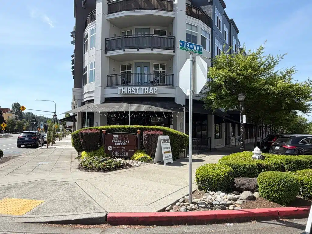 Living in South Juanita, Kirkland: 2026 Neighborhood & Real Estate Guide 2 Juanita Village mixed-use retail and condo building exterior at NE 119th Way in Kirkland WA featuring local shops and walkable streetscape.