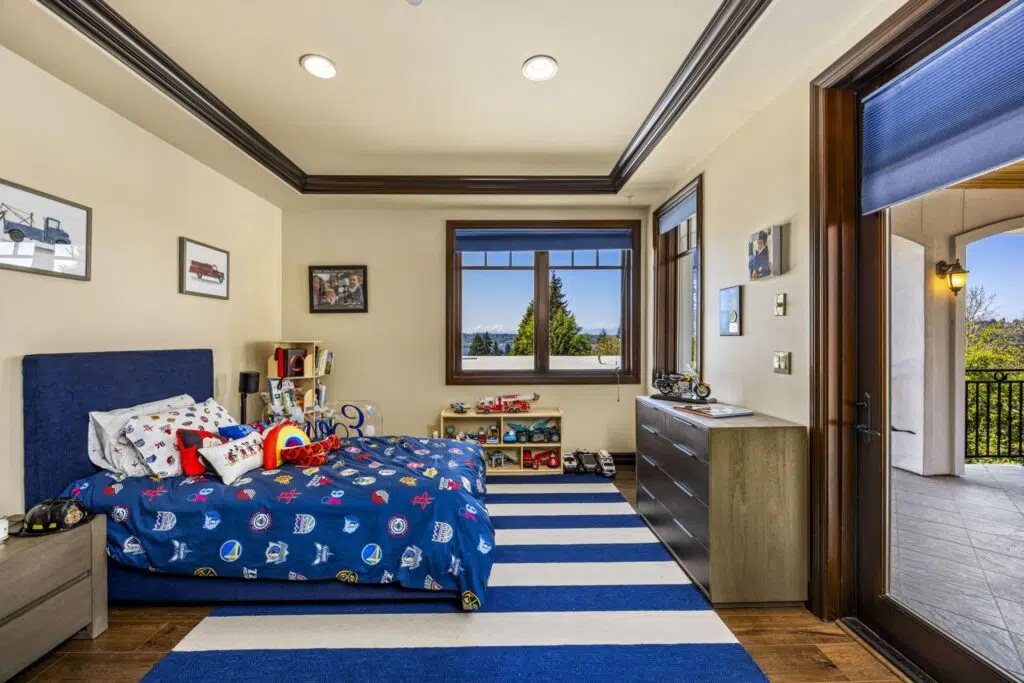 Upper-level bedroom with private balcony access, designer ceiling detail, and large windows offering territorial views.